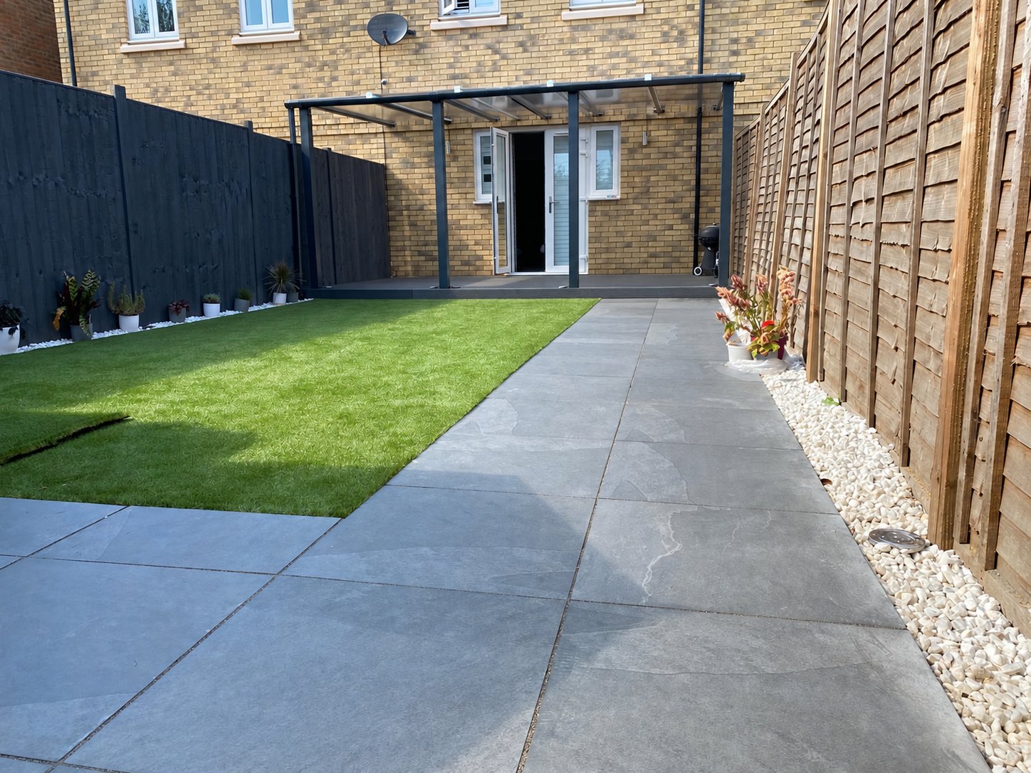 Canterbury porcelain patio, artificial grass and steel pergola