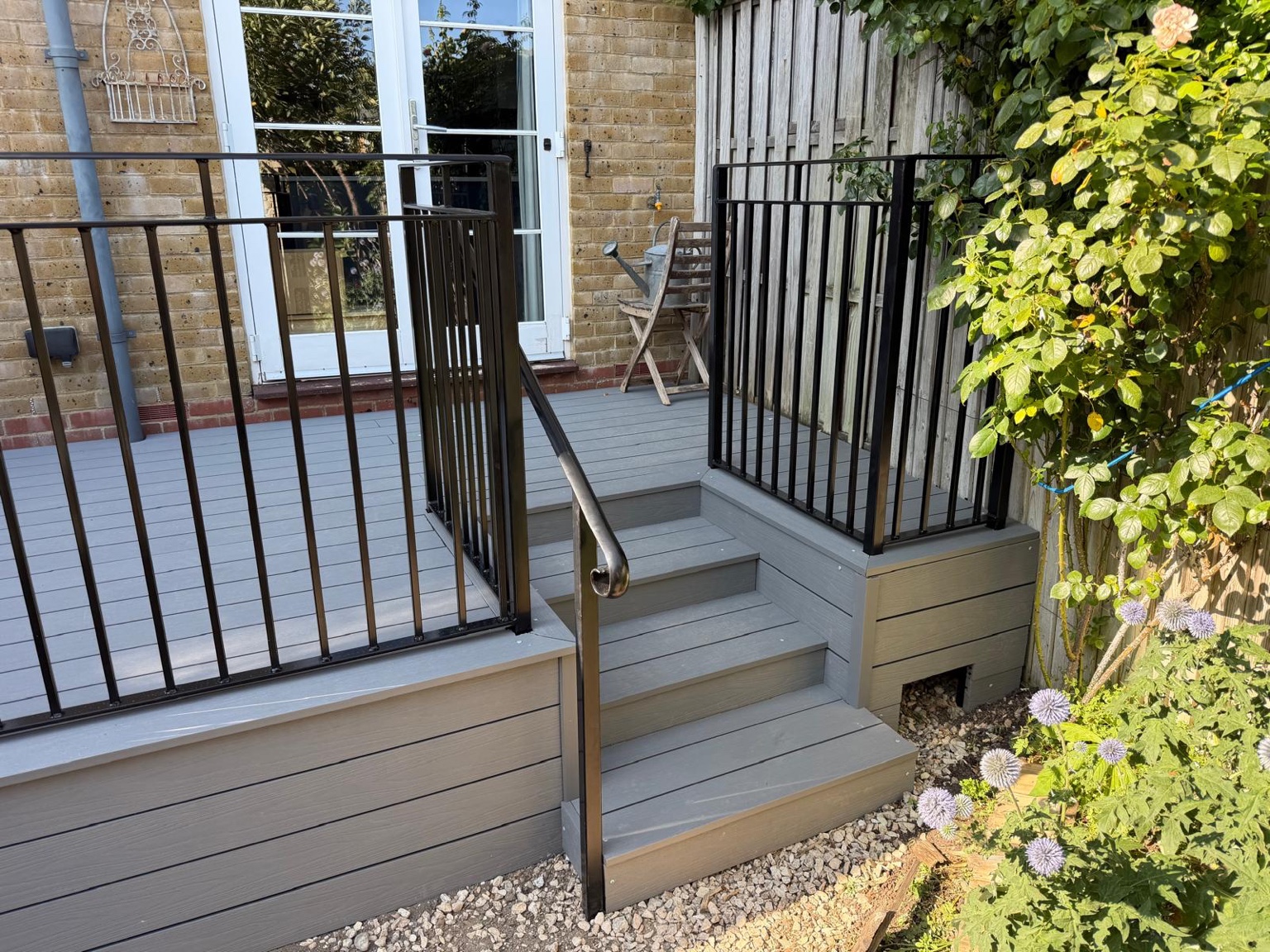 Deal decking with black railings, inset steps and a handrail