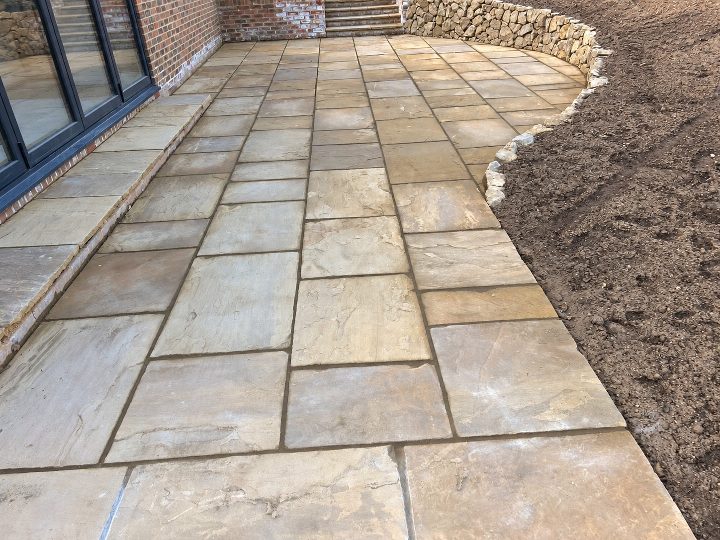 York stone patio with a curved Kentish ragstone wall in Sevenoaks