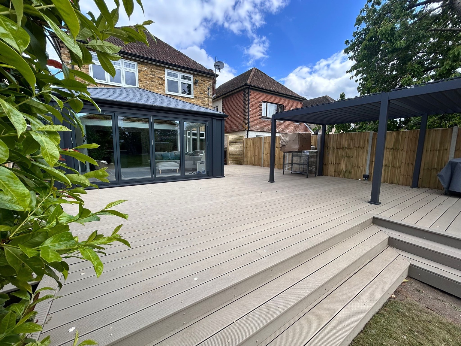 Broad steps connect the decking with the lawn.